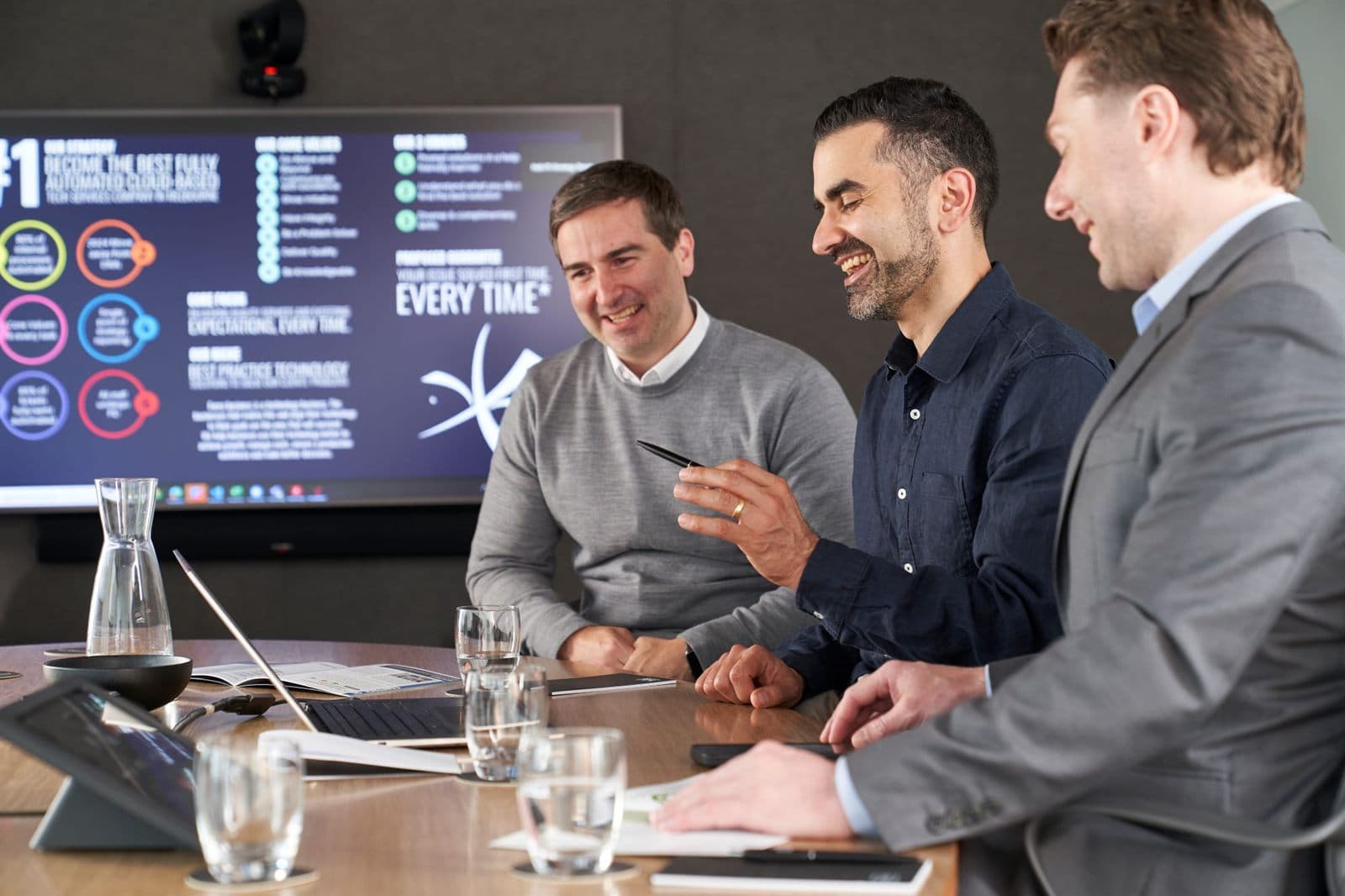 Three of the Intuitive IT team talking in the boardroom